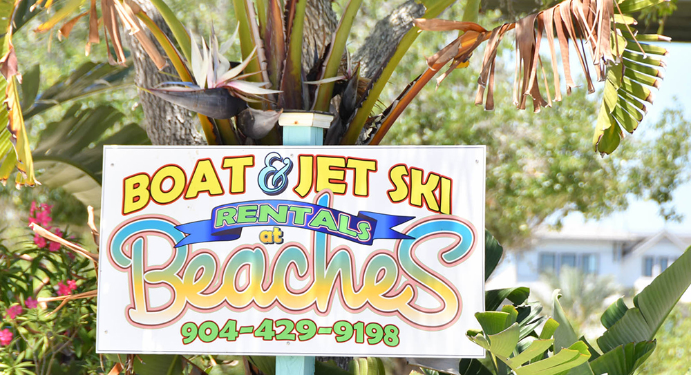 Sign that reads "Boat & Jet Ski Rentals at Beaches 904-429-91981"