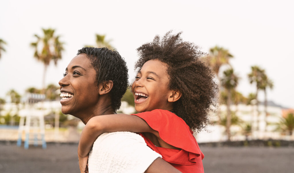 Happy African family on the beach during summer.